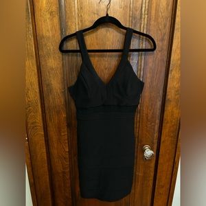 Black bodycon dress with sheer strips and plunging neck.